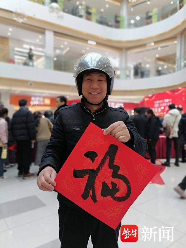 展示自己领到的“福”字。张建波 摄